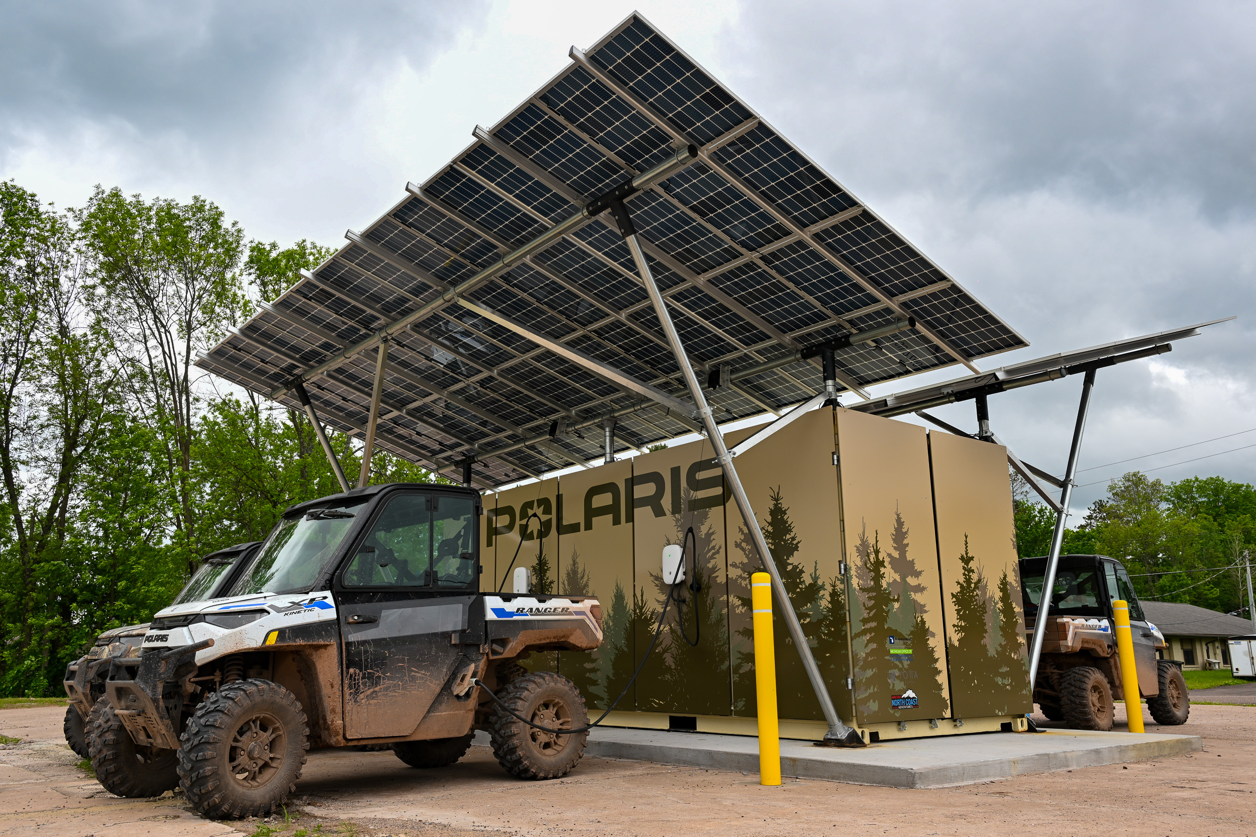 Polaris electric EVs charging on a trailside solar-powered charger in Ontonagon, MI