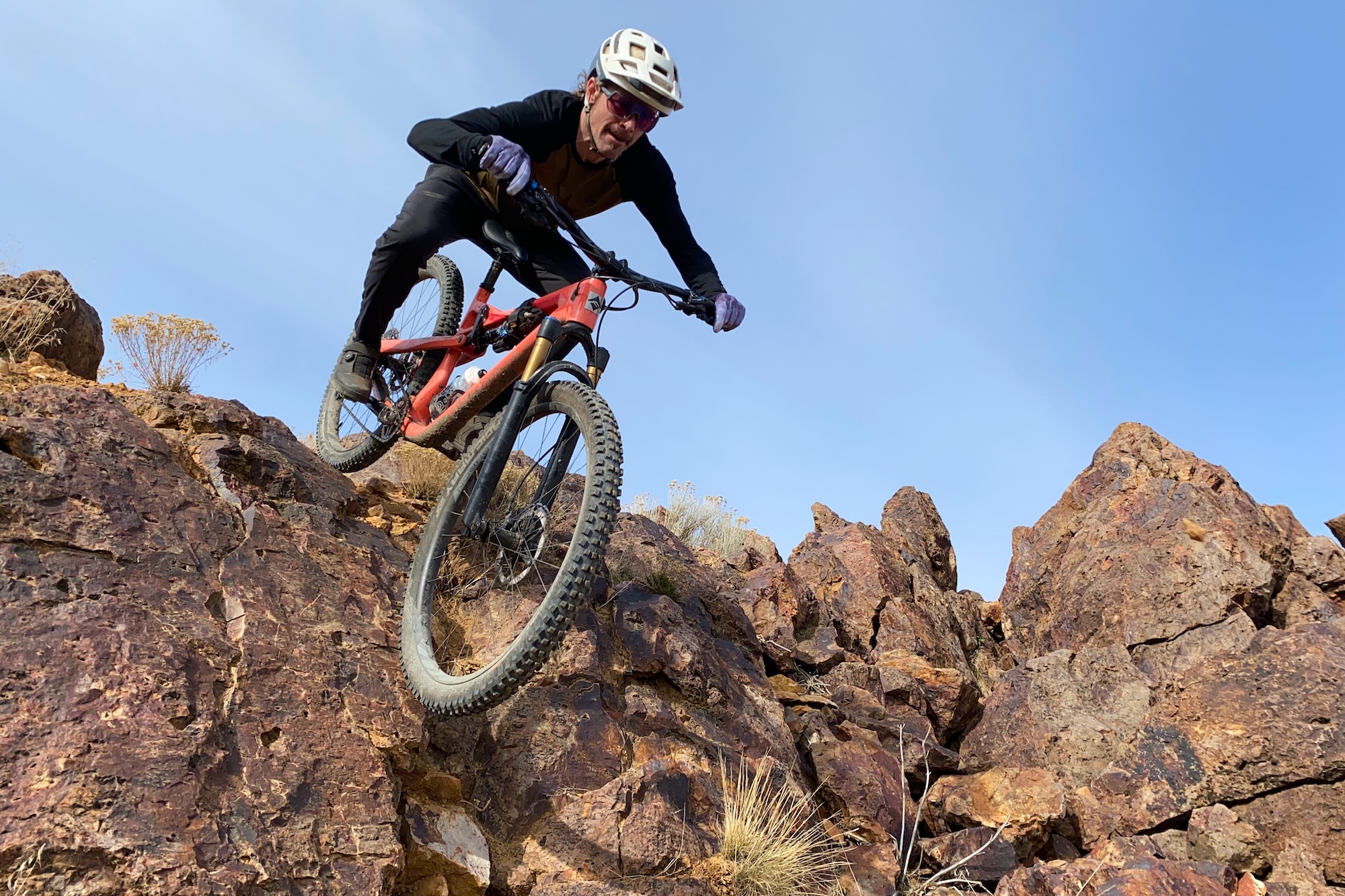 a mountain bike rider navigating technical terrain wearing a mountain bike helmet